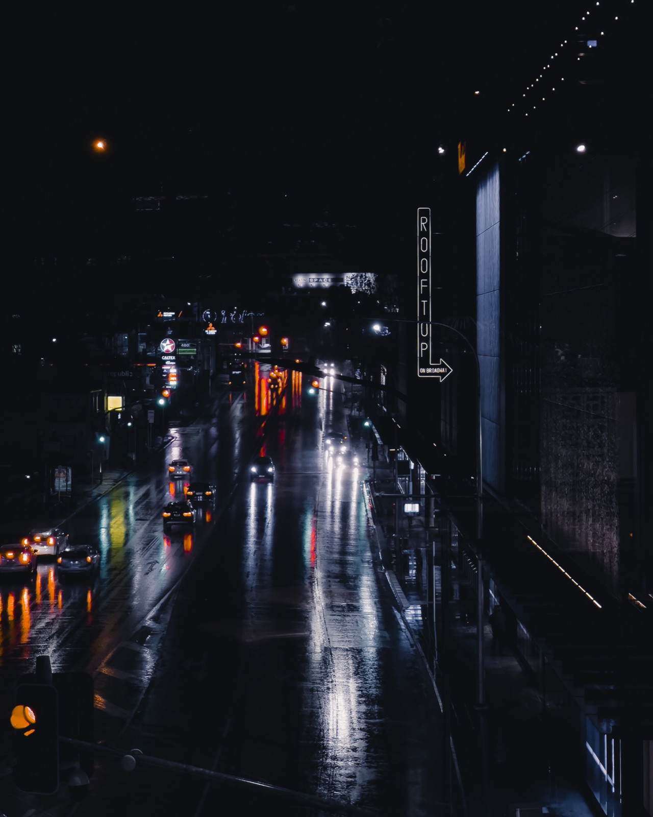 A rainy scene with reflections on a wet surface turning city lights into a secondary image